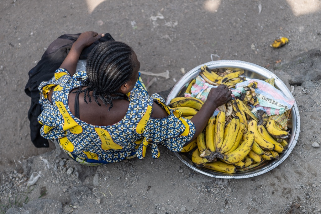 A woman sells bananas on the shores of Lake Kivu in Goma, Democratic Republic of the Congo, Monday, Jan. 26, 2026, a year after M23 took control of the city. (AP Photo/Moses Sawasawa)