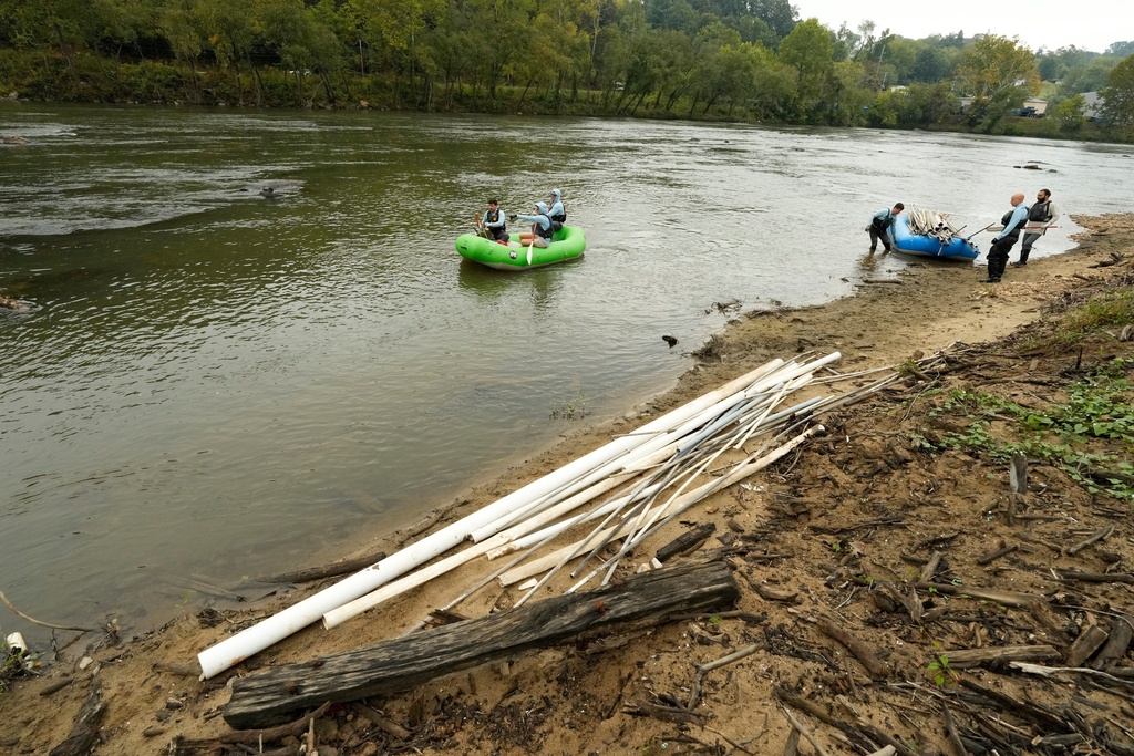 Members of the MountainTrue cleanup crew remove PVC pipes from the French Broad River on Wednesday, Sept. 17, 2025, in Asheville, N.C. (AP Photo/Chris Carlson)