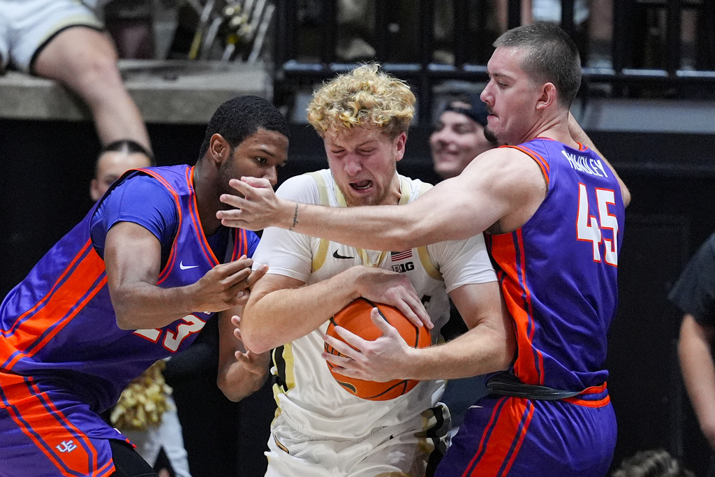 Purdue guard Jack Benter (14) is tied up by Evansville forward AJ Casey (23) and forward Trent Hundley (45) during the first half of an NCAA college basketball game in West Lafayette, Ind., Tuesday, Nov. 4, 2025. (AP Photo/Michael Conroy)