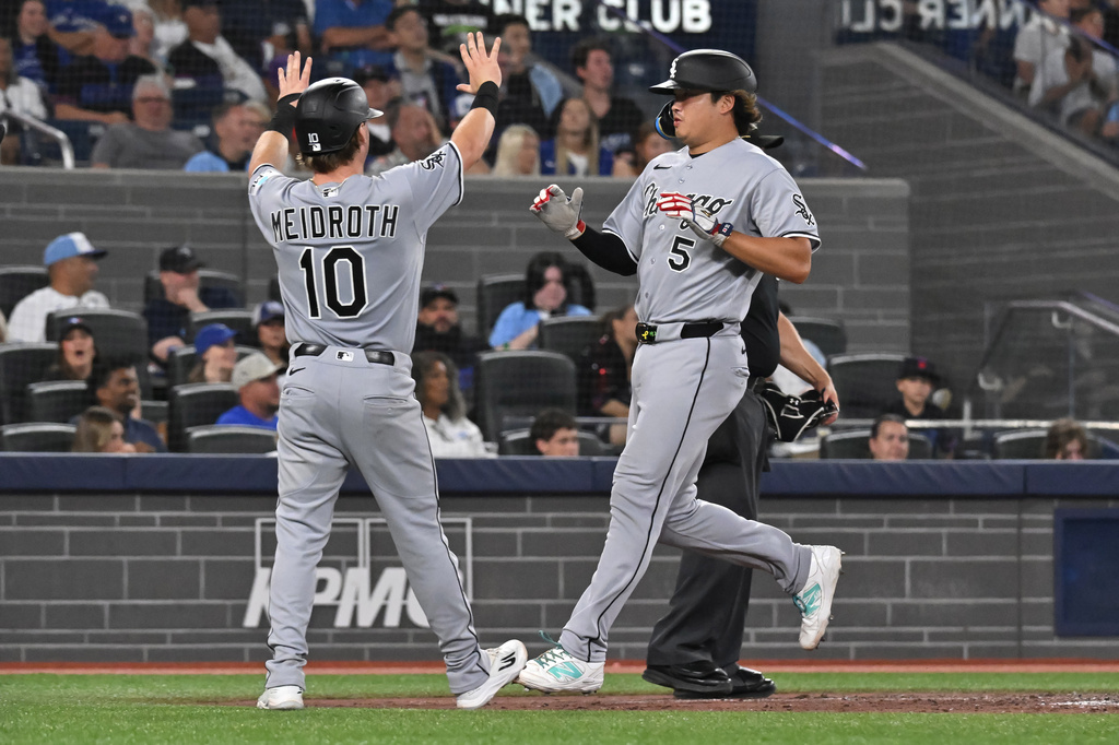 Chicago White Sox's Chase Meidroth (10) and Munetaka Murakami (5) celebrate after scoring on a three-RBI double by teammate Colson Montgomery during the fifth inning of a baseball game against the Toronto Blue Jays in Toronto, Friday, July 17, 2026. (Jon Blacker/The Canadian Press via AP)