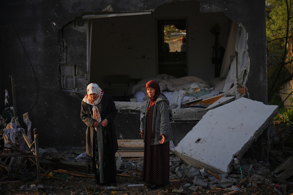 Residents inspect a house destroyed by an Iranian missile strike in Zarzir, northern Israel, Friday, March 13, 2026. (AP Photo/Ariel Schalit)