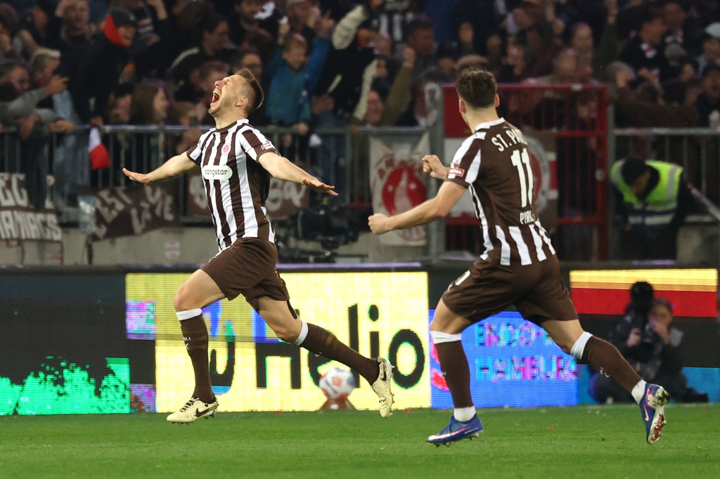 St. Pauli's Karol Mets, left, celebrates after scoring a goal during the Bundesliga soccer match between FC St. Pauli and 1. FC Köln, Friday, April 17, 2026, in Hamburg, Germany. (Christian Charisius/dpa via AP)