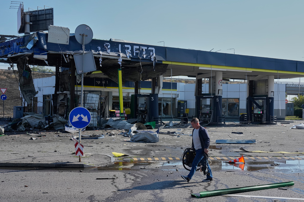 A worker leaves the damaged gas station after a Russian drone strike in Kyiv, Ukraine, Friday, Sept. 11, 2026. (AP Photo/Efrem Lukatsky)