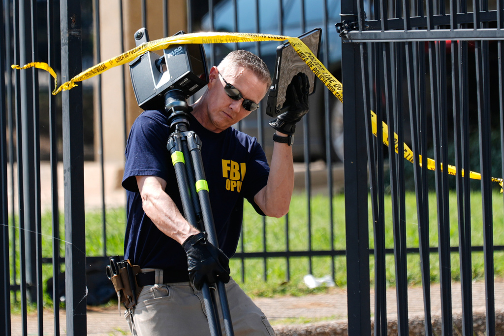 FBI agents investigate the crime scene near a U.S. Immigration and Customs Enforcement office Thursday, Sept. 25, 2025, in Dallas. (AP Photo/Tony Gutierrez)