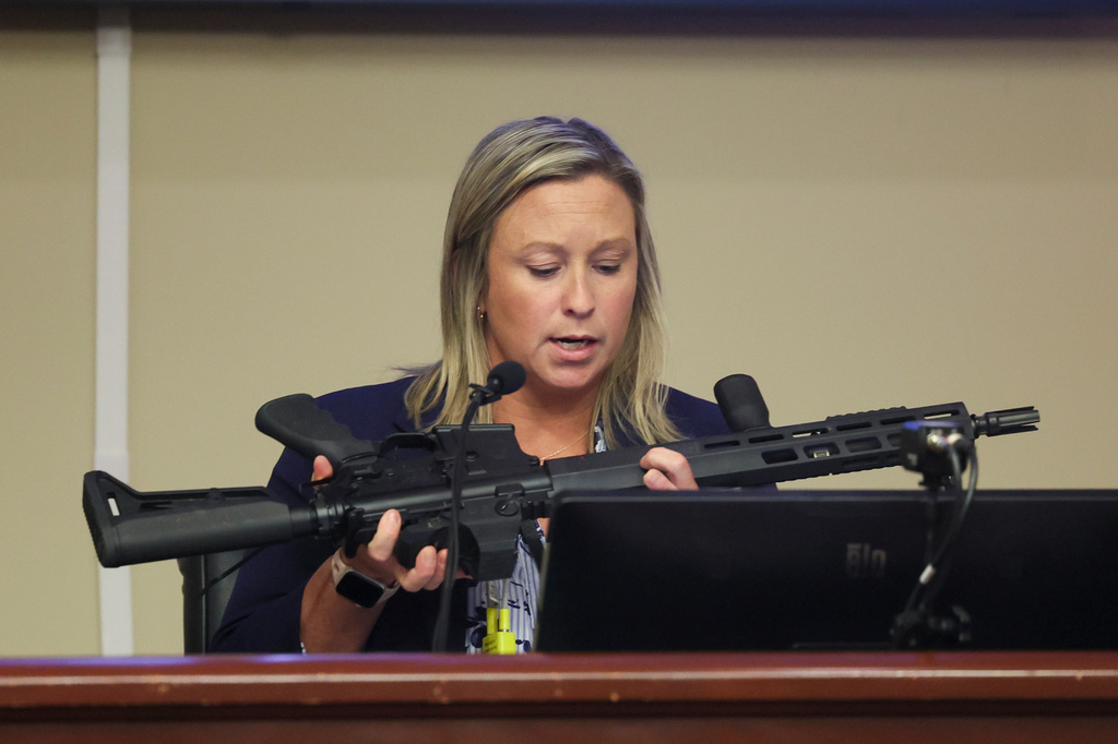 Ashley Gilland, an investigator with the Barrow County District Attorney's office, looks over the assault rifle used in the Apalachee High School shooting by suspect Colt Gray during Gray's sentencing at Barrow County Superior Court, Monday, July 27, 2026, in Winder, Ga. (Jason Getz/Atlanta Journal-Constitution via AP)