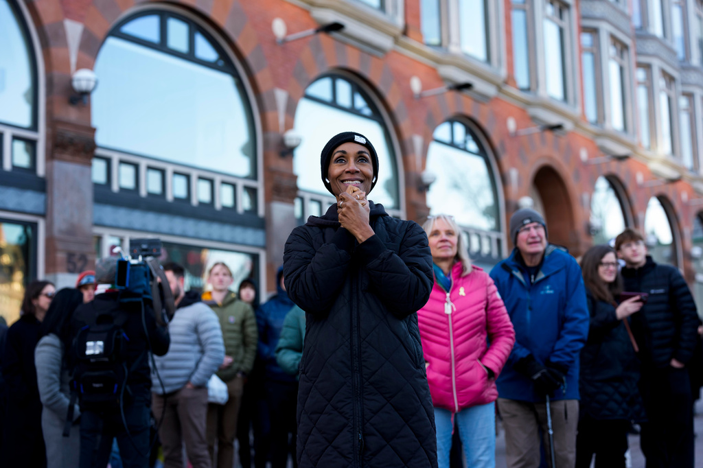 People react on Elgin Street as the Artemis II moon rocket lifts off, on a livestream displayed on the Kipnes Lantern of the National Arts Centre in Ottawa, Ontario, Wednesday, April 1, 2026. (Justin Tang/The Canadian Press via AP)