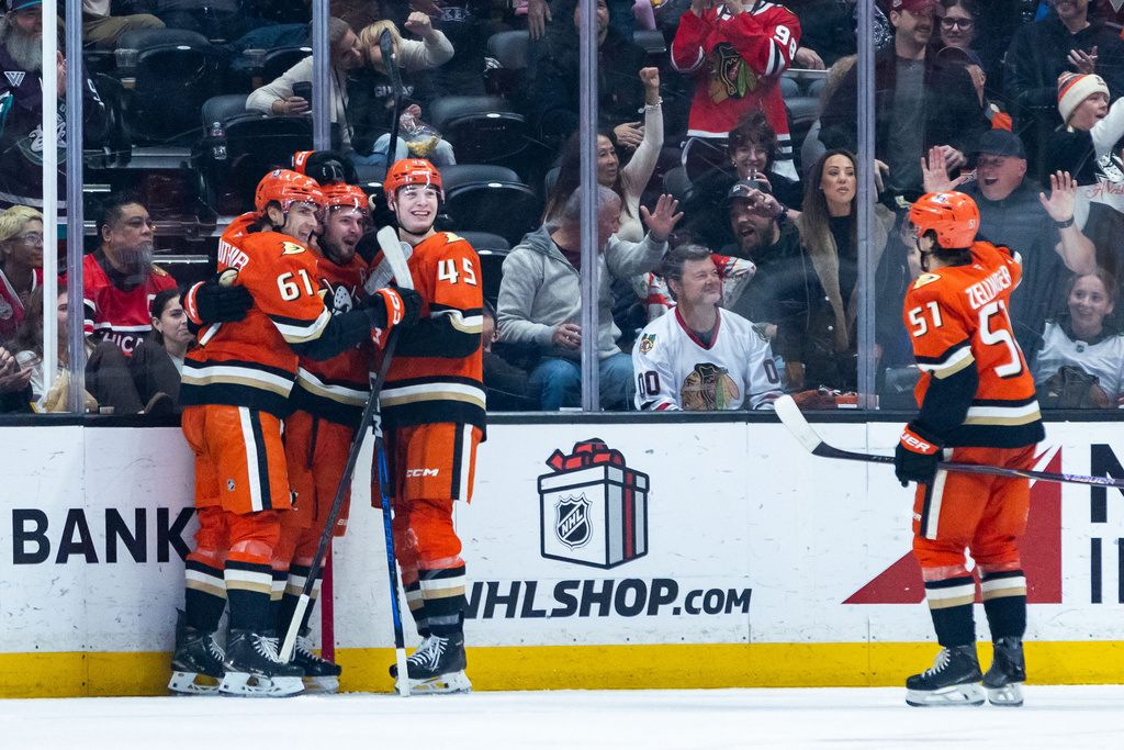 Anaheim Ducks left wing Cutter Gauthier (61), center Mason McTavish (23), right wing Beckett Sennecke (45), and defenseman Olen Zellweger (51) celebrate after scoring against the Chicago Blackhawks during the second period of an NHL hockey game Sunday, Dec. 7, 2025, in Anaheim, Calif. (AP Photo/Ethan Swope)