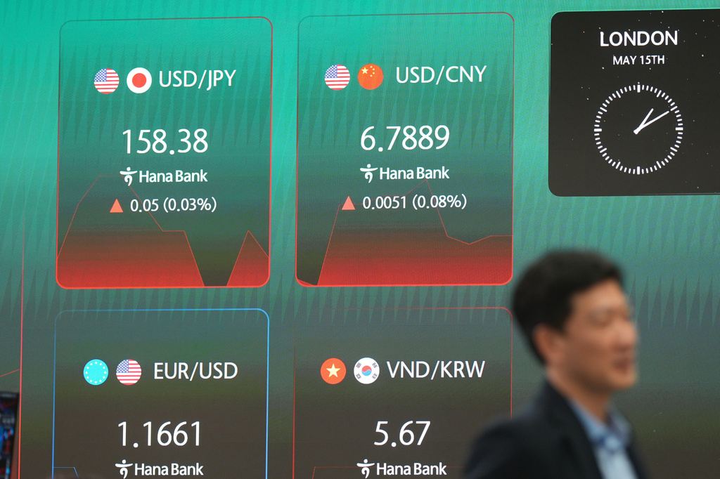 A dealer walks near the screens showing the foreign exchange rates at a dealing room of Hana Bank in Seoul, South Korea, Friday, May 15, 2026. (AP Photo/Lee Jin-man)