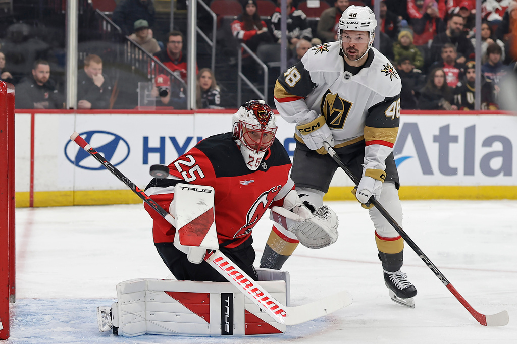 New Jersey Devils goaltender Jacob Markstrom and Vegas Golden Knights center Tomas Hertl (48) watch a shot go wide of the net during the first period of an NHL hockey game Friday, Dec. 5, 2025, in Newark, N.J. (AP Photo/Adam Hunger)