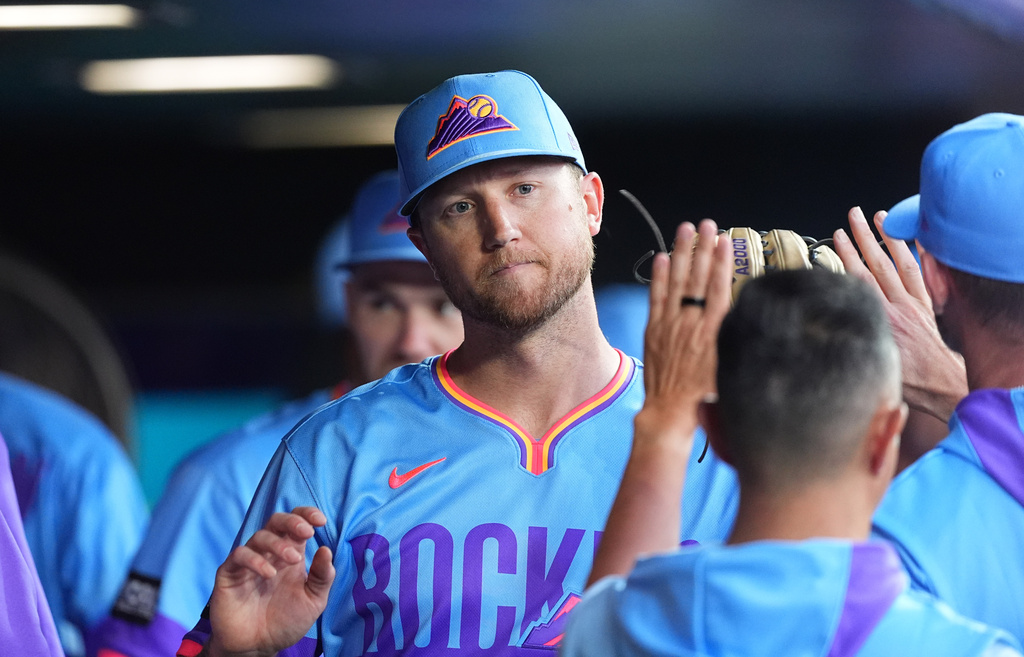 Colorado Rockies starting pitcher Kyle Freeland, center, is congratulated as he returns to the dugout after he was pulled from the mound in the eighth inning of a baseball game against the Pittsburgh Pirates, Friday, June 19, 2026, in Denver. (AP Photo/David Zalubowski)