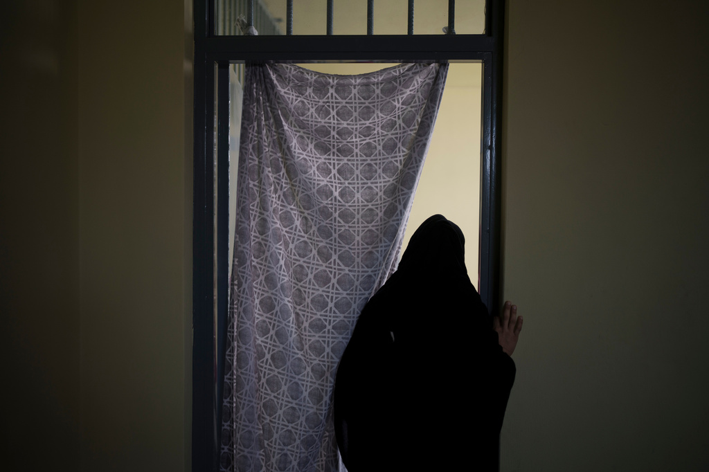 FILE - An Afghan woman walks out of a cell inside the women's section of the Pul-e-Charkhi prison in Kabul, Afghanistan, on Sept. 23, 2021. (AP Photo/Felipe Dana, File)