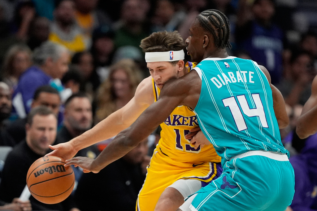 Charlotte Hornets forward Moussa Diabate fouls Los Angeles Lakers guard Austin Reaves during the first half of an NBA basketball game Monday, Nov. 10, 2025, in Charlotte, N.C. (AP Photo/Chris Carlson)