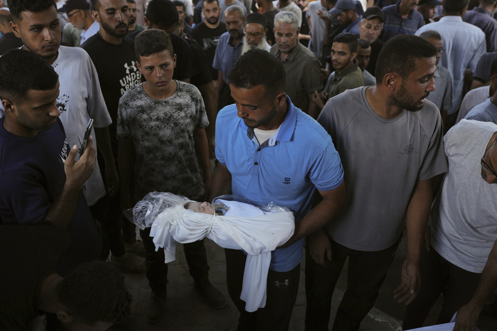 A relative carries the body of Palestinian infant Jabr Al-Ashhab, who was killed in an Israeli military strike, during his funeral outside Shifa Hospital in Gaza City, Thursday, Sept. 4, 2025. (AP Photo/Jehad Alshrafi)