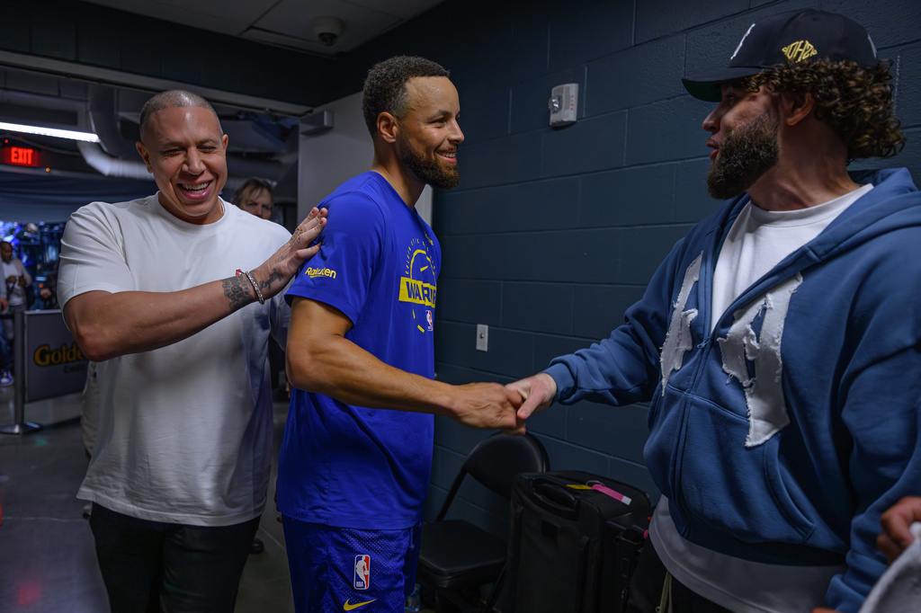 Golden State Warriors' Stephen Curry (30), center, shakes hands with Michael Bibby Jr. after being introduced by his father, left, former Sacramento Kings player Mike Bibby, before an NBA basketball game between the Warriors and the Kings in Sacramento, Calif., Friday, April 10, 2026. (Jose Carlos Fajardo/Bay Area News Group via AP)