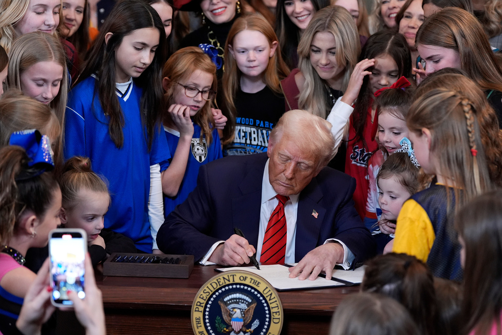 FILE - President Donald Trump signs an executive order at the White House in Washington, Feb. 5, 2025, barring transgender female athletes from competing in women's or girls' sporting events. (AP Photo/Alex Brandon, File)