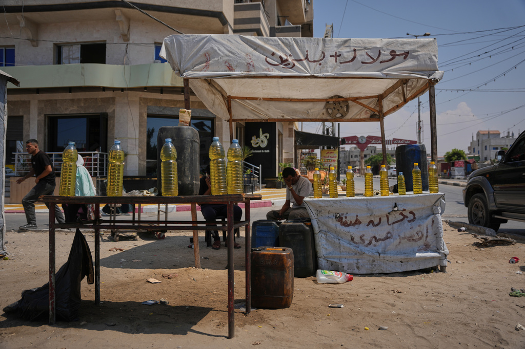 A Palestinian vendor offers bottles of diesel for sale in al-Maghazi refugee camp, central Gaza Strip, Saturday, Aug. 15, 2026. (AP Photo/Abdel Kareem Hana)