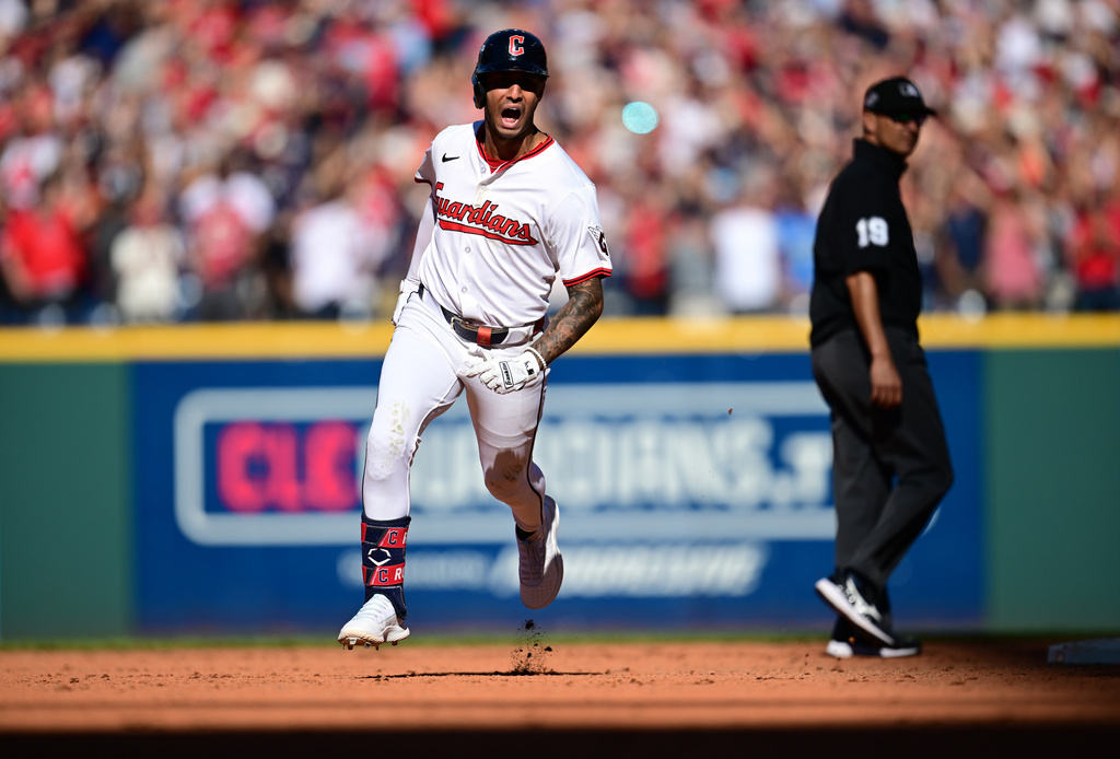 Cleveland Guardians Brayan Rocchio reacts as he rounds the bases after hitting a solo home run in the eighth inning of Game 2 of the American League Wild Card baseball playoff series against the Detroit Tigers in Cleveland, Wednesday, Oct. 1, 2025. Umpire Vic Carapazza looks on at right. (AP Photo/David Dermer)