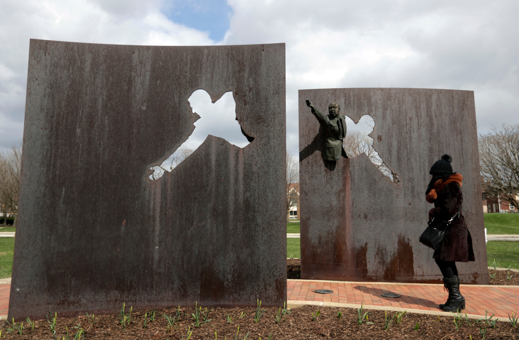 FILE - A visitor pauses as she visits the memorial "Landmark for Peace" commemorating the site where Robert Kennedy delivered his immortal words on the night of Martin Luther King Jr's assassination in Indianapolis, Wednesday, April 4, 2018. The park where Kennedy called for peace and unity just hours after the assassination of King is being designated a National Historic Site. (AP Photo/Michael Conroy, File)