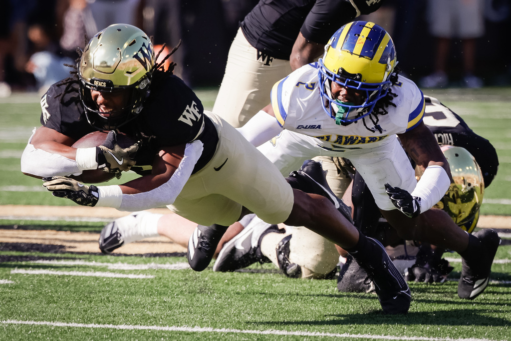 Wake Forest's Ty Clark III (0) is tackled by Delaware's Mysonne Pollard (2) during the first half of an NCAA football game, Saturday, Nov. 22, 2025, in Winston-Salem, N.C. (Allison Lee Isley/The Winston-Salem Journal via AP)