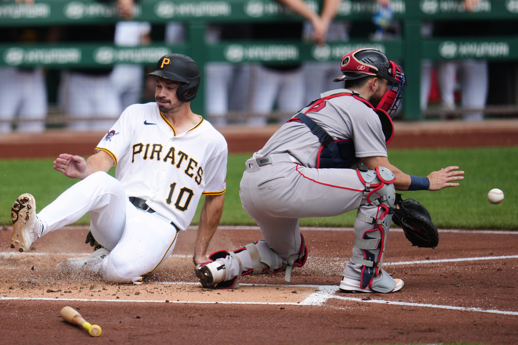 Pittsburgh Pirates' Bryan Reynolds (10) scores ahead of a throw to Boston Red Sox catcher Connor Wong, right, on a single by Brandon Lowe off Red Sox pitcher Patrick Sandoval during the first inning of a baseball game in Pittsburgh, Sunday, Aug. 16, 2026. (AP Photo/Gene J. Puskar)