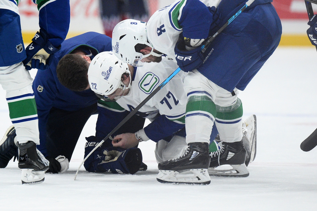 Vancouver Canucks center Filip Chytil (72) is tended to after he was injured during the first period of an NHL hockey game against the Washington Capitals, Sunday, Oct. 19, 2025, in Washington. (AP Photo/Nick Wass)