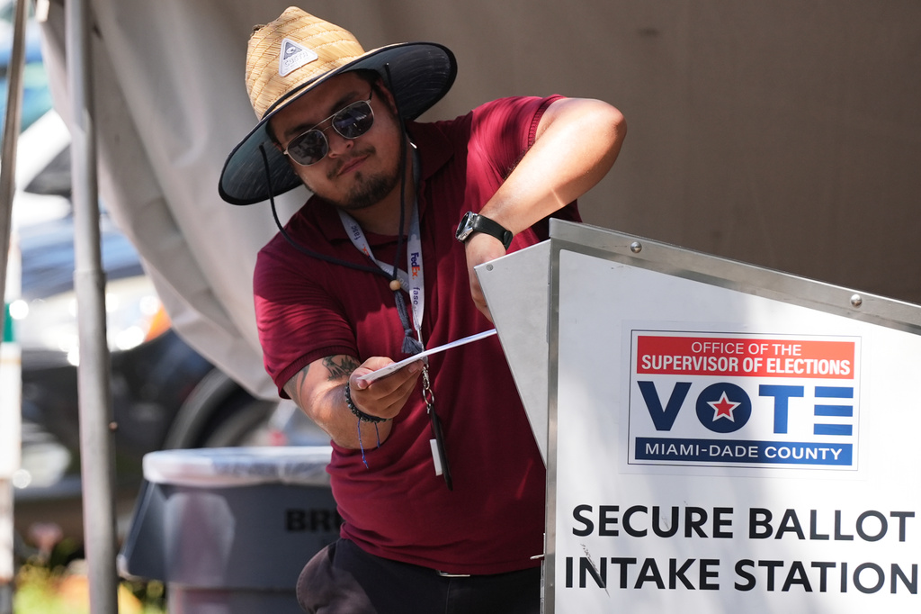 An election worker places a vote-by-mail ballot into a secure bin at the Miami-Dade County Supervisor of Elections Office during the Florida primary election in Doral, Fla., Tuesday, Aug. 18, 2026. (AP Photo/Lynne Sladky)