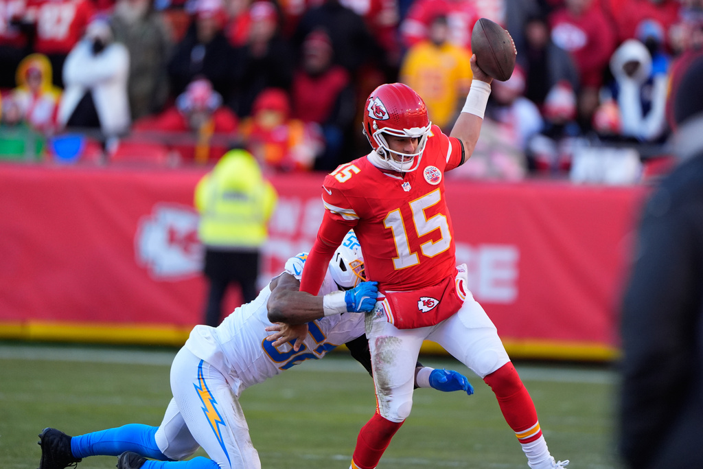 Kansas City Chiefs quarterback Patrick Mahomes (15) is pushed out of bounds by Los Angeles Chargers outside linebacker Khalil Mack, left, during the second half of an NFL football game Sunday, Dec. 14, 2025, in Kansas City, Mo. (AP Photo/Charlie Riedel)