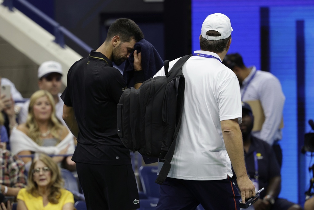 Novak Djokovic, of Serbia, leaves the court with a trainer against Cameron Norrie, of Great Britain, during the third round of the U.S . Open tennis championships, Friday, Aug. 29, 2025, in New York. (AP Photo/Adam Hunger)