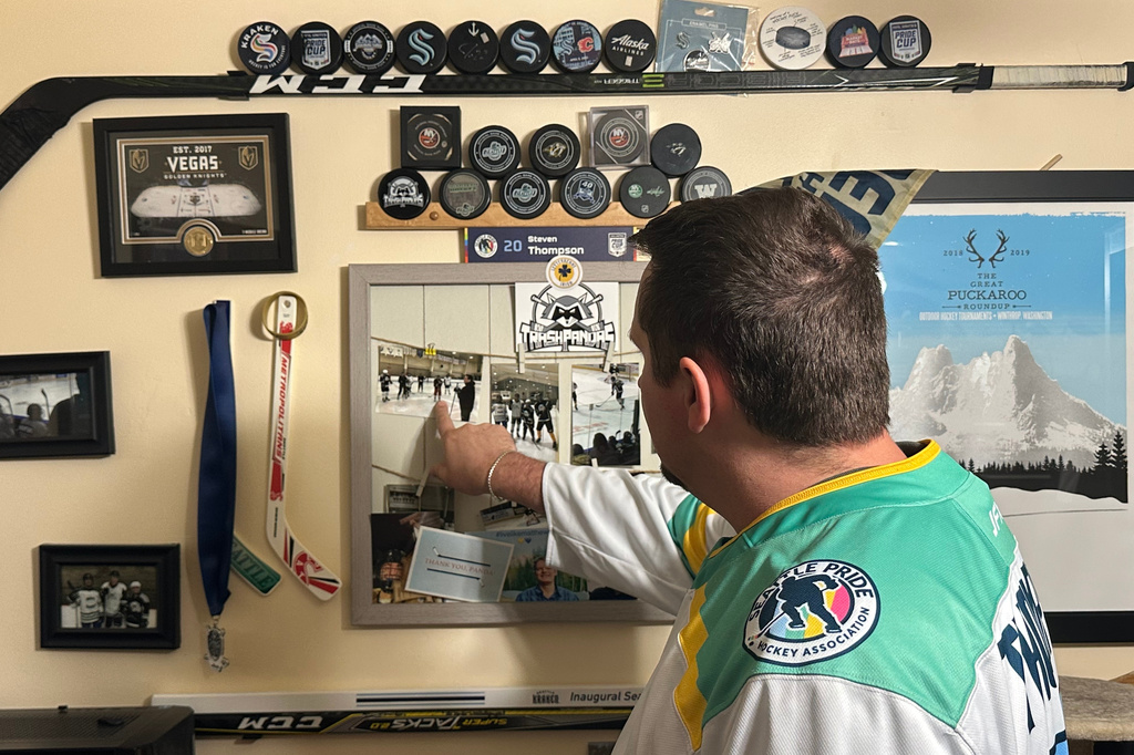 Steven Thompson, co-founder of the Seattle Pride Hockey Association (SPHA), sifts through some of his hockey memorabilia at his home in Des Moines, Wash., Monday, April 27, 2026. (AP Photo/Andrew Destin)