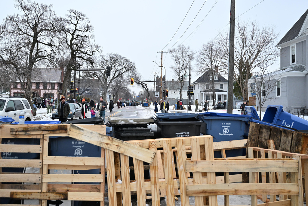 The street is barricaded by a makeshift memorial honoring the victim of a fatal shooting involving federal law enforcement agents, near the site of the shooting, Thursday, Jan. 8, 2026, in Minneapolis. (AP Photo/Tom Baker)