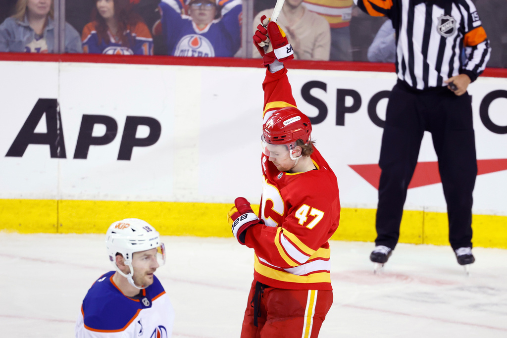 Calgary Flames' Connor Zary celebrates a goal as Edmonton Oilers' Zach Hyman skates past during the second period of an NHL hockey game in Calgary, Wednesday, Feb. 4, 2026. (Larry MacDougal/The Canadian Press via AP)