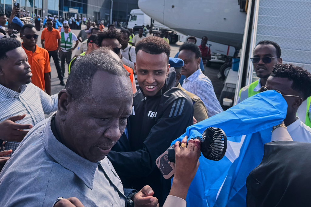 Referee Omar Artan, center, who was denied entry to the United States, is welcomed by supporters upon his arrival in Mogadishu, Somalia, Wednesday, June 10, 2026. (AP Photo/Farah Abdi Warsameh)