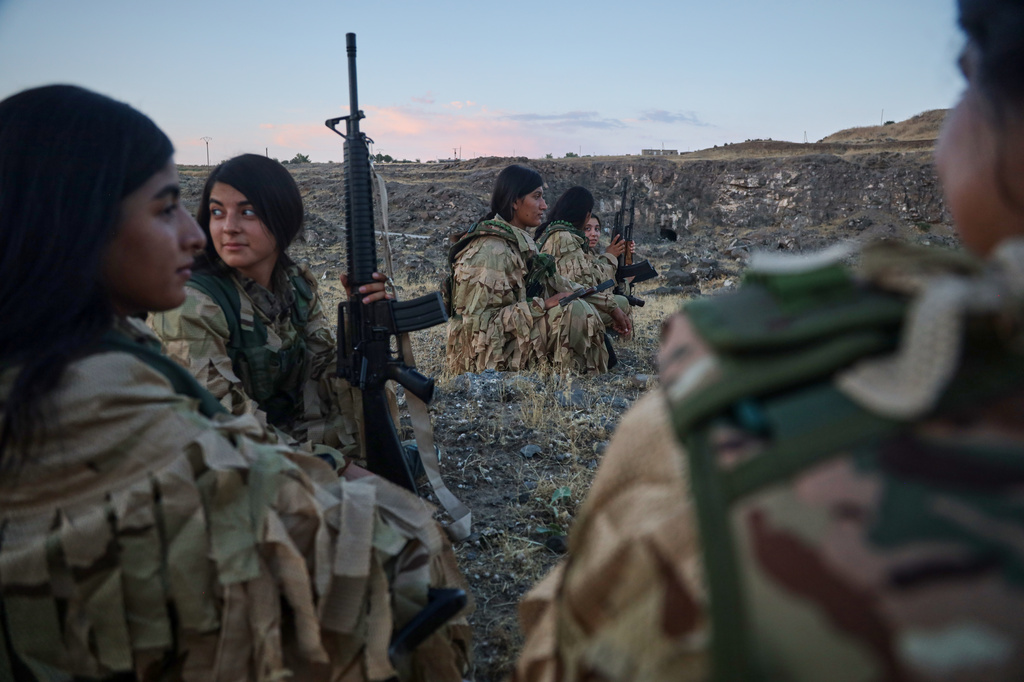 Fighters with the Kurdish Women's Protection Units, or YPJ, rest during a break in military training in the countryside of Derik, also known as al-Malikiyah, northeastern Syria, Saturday, Sept. 12, 2026.(AP Photo/Baderkhan Ahmad)