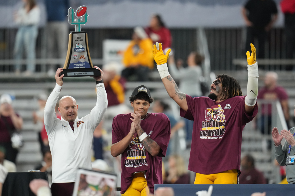 Minnesota head coach P.J. Fleck, wide receiver Jalen Smith, and safety Albert Nunes lift the trophy after defeating New Mexico in a Rate Bowl NCAA college football game, Friday, Dec. 26, 2025, in Phoenix. (AP Photo/Rick Scuteri)