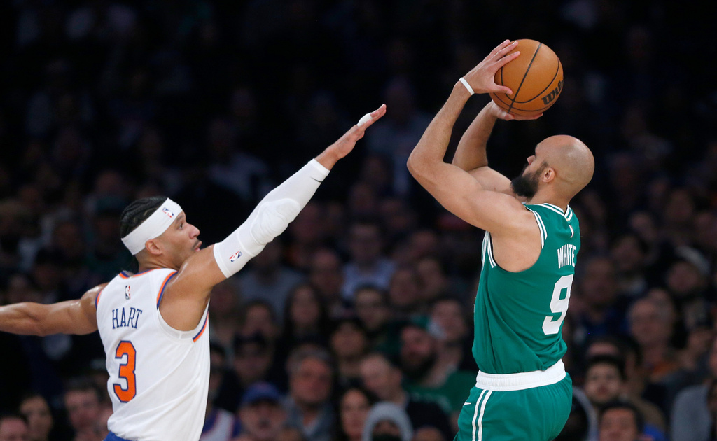 New York Knicks guard Josh Hart, left, defends Boston Celtics guard Derrick White during the first half of an NBA basketball game Thursday, April 9, 2026, in New York. (AP Photo/John Munson)
