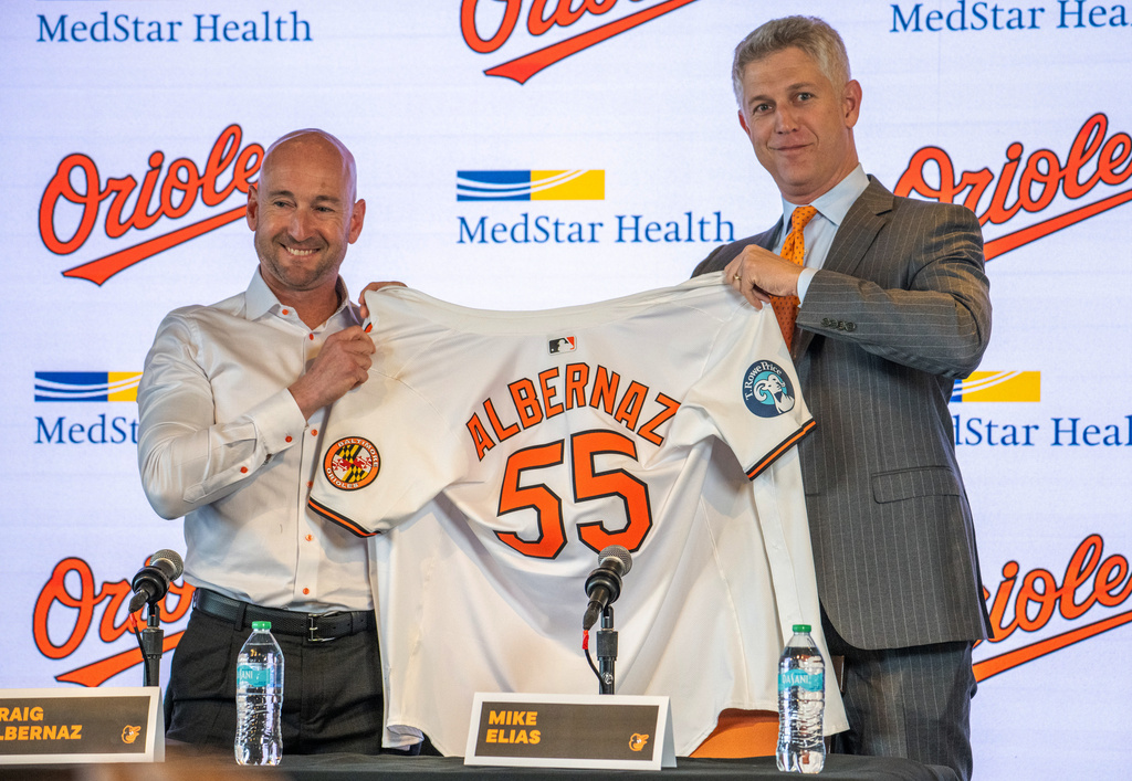 Baltimore Orioles general manager Mike Elias, right, presents the baseball club's new manager Craig Albernaz with his team jersey after introducing him during a news conference, Tuesday, Nov. 4, 2025, in Baltimore. (Jerry Jackson/The Baltimore Banner via AP)