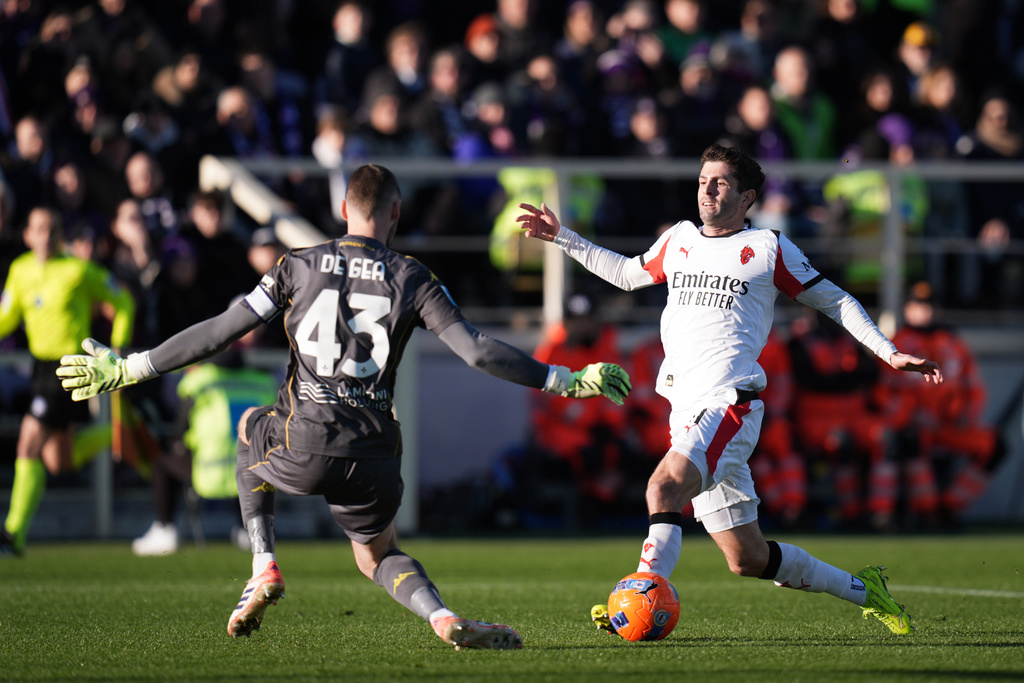 AC Milan's Christian Pulisic fights for the ball with Fiorentina goalkeeper David De Gea, left, during the Serie A soccer match between Fiorentina and Milan in Florence, Italy, Sunday, Jan. 11, 2026. (Massimo Paolone/LaPresse via AP)