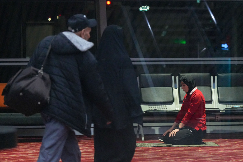 Members of Iran's women's football team pray at the Kuala Lumpur International Airport in Sepang, Malaysia, Monday, March 16, 2026. (AP Photo/Azneal Ishak)