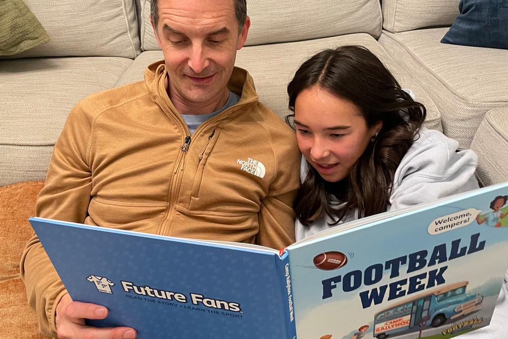 In this image provided by Future Fans, Michael and Estelle Gold read "Football Week" a football related book, Sept. 9, 2025, in Columbus, Ohio. (Delia Gold via AP)