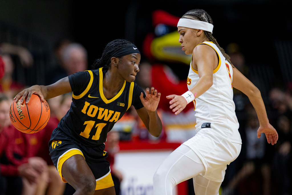Iowa guard Chazadi Wright (11) dribbles as Iowa State guard Jada Williams, right, defends during an NCAA college basketball game in Ames, Iowa, Wednesday, Dec. 10, 2025. (Nick Rohlman/The Gazette via AP)