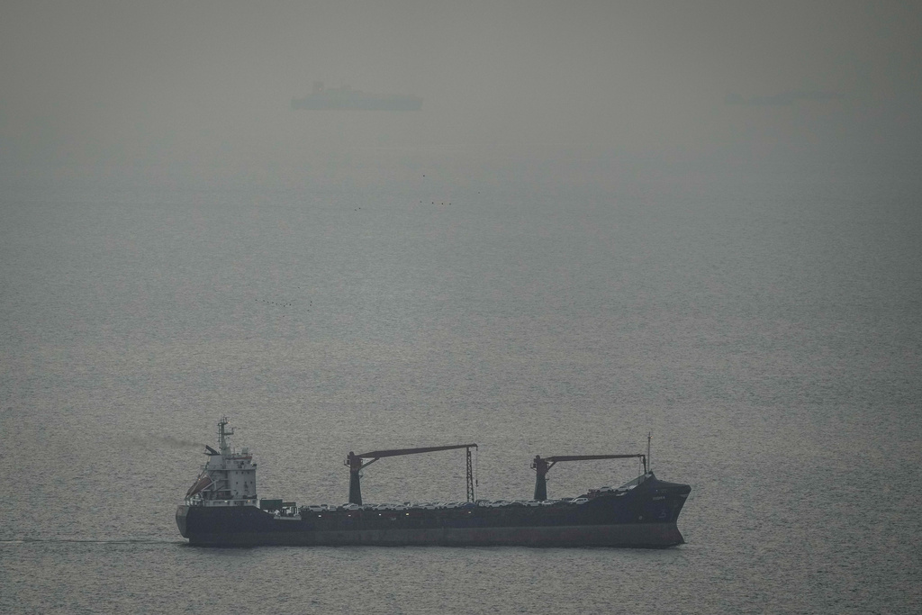 A cargo ship carrying vehicles sails through the Arabian Gulf toward the Strait of Hormuz in the United Arab Emirates, Sunday, March 22, 2026. (AP Photo)