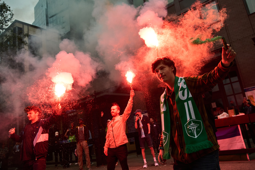 Fans set off flares as Seattle Sounders fans march before an MLS soccer match against the Portland Timbers, Thursday, July 16, 2026, in Seattle. (AP Photo/Lindsey Wasson)