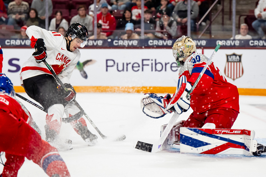 Canada's Tij Iginla (11) attacks the net defended by Czechia goaltender Michal Orsulak (30) during second-period IIHF World Junior Championship hockey game action in Minneapolis, Friday, Dec. 26, 2025. (Christopher Katsarov/The Canadian Press via AP)