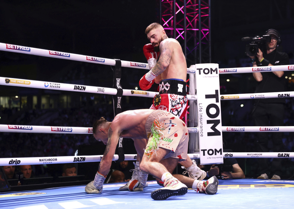 Lewis Crocker, top, knocks down Paddy Donovan during an IBF world welterweight bout at the SSE Arena, Saturday, Sept. 13, 2025, in Belfast, Northern Ireland. (Peter Morrison/PA via AP)