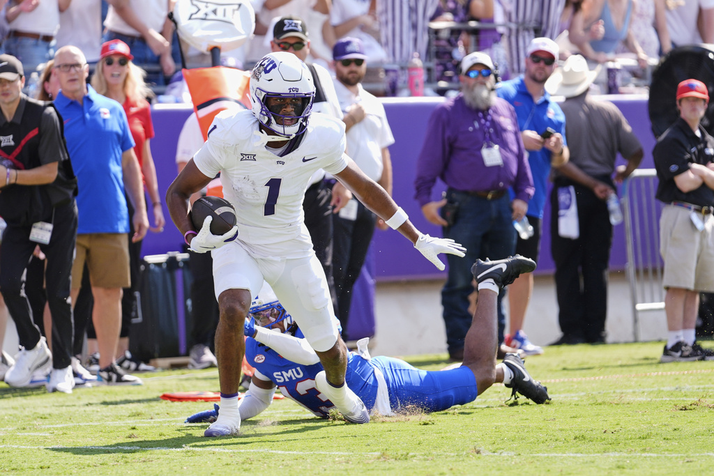 TCU wide receiver Eric McAlister (1) breaks a tackle attempt by SMU cornerback Jaelyn Davis-Robinson (13) before sprinting to the end zone for a touchdown in the first half of an NCAA college football game, Saturday, Sept. 20, 2025, in Fort Worth, Texas. (AP Photo/Tony Gutierrez)