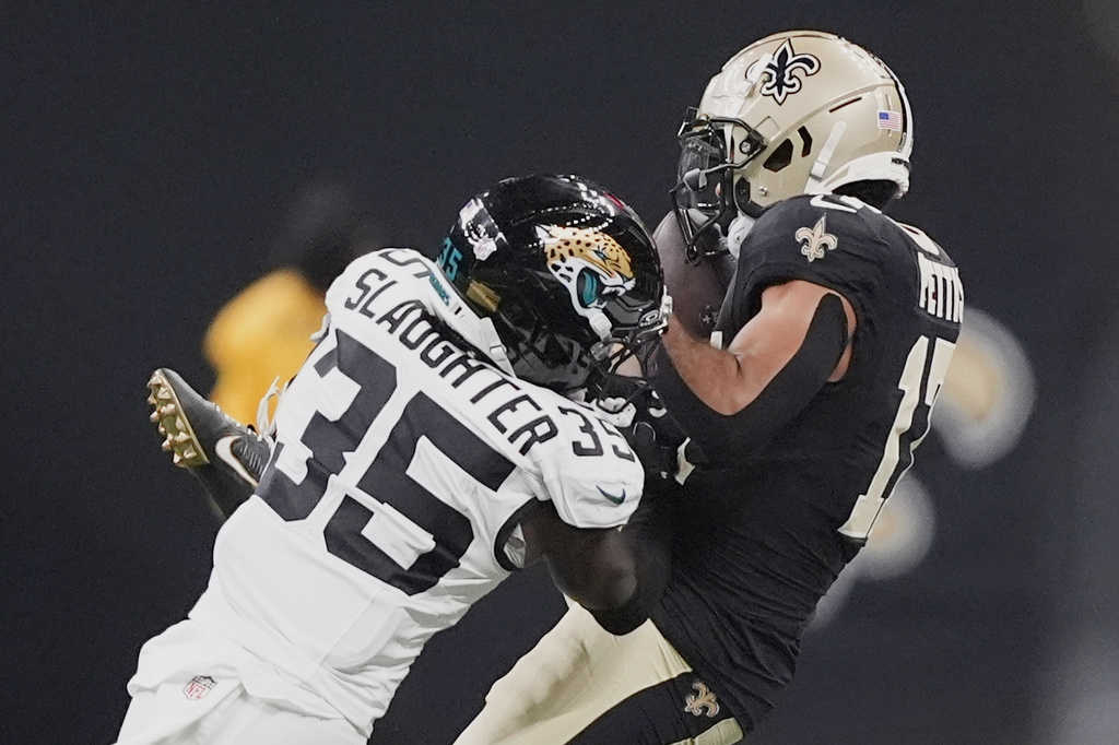 New Orleans Saints wide receiver Dante Pettis makes a reception against Jacksonville Jaguars cornerback Doneiko Slaughter (35) in the second half of an NFL preseason football game in New Orleans, Sunday, Aug. 17, 2025. (AP Photo/Gerald Herbert)