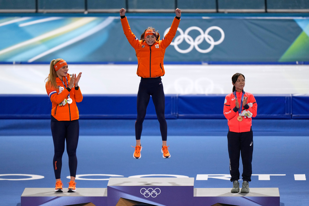 Femke Kok of the Netherlands, center and gold medal celebrates with Jutta Leerdam of the Netherlands, left and silver medal, and Miho Takagi of Japan, right and bronze medal, on the podium of the women's 500 meters speedskating race at the 2026 Winter Olympics, in Milan, Italy, Sunday, Feb. 15, 2026. (AP Photo/Luca Bruno)