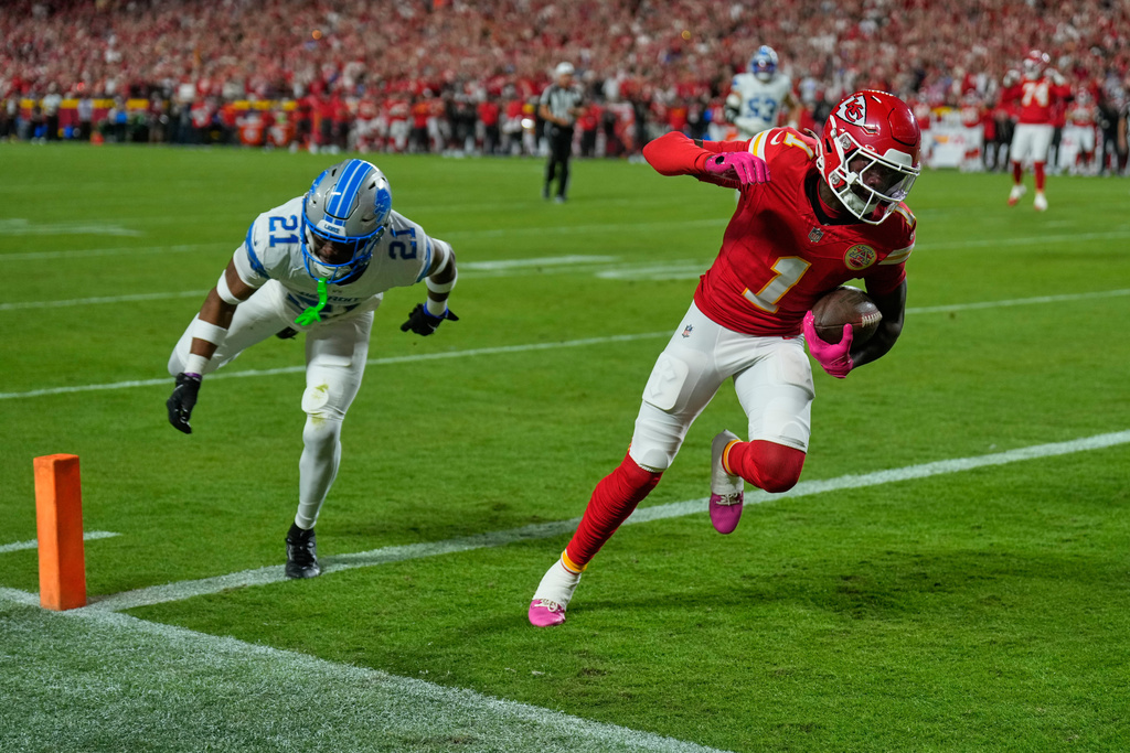Kansas City Chiefs wide receiver Xavier Worthy (1) scores past Detroit Lions cornerback Amik Robertson (21) during the first half of an NFL football game Sunday, Oct. 12, 2025, in Kansas City, Mo. (AP Photo/Charlie Riedel)