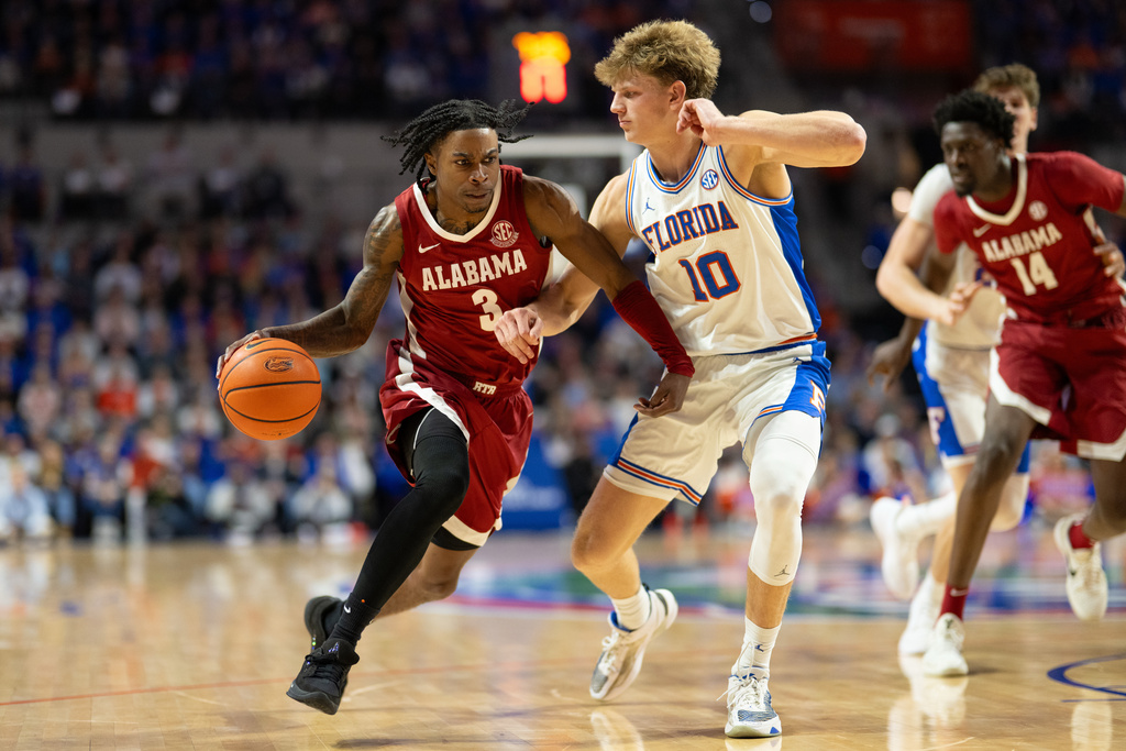 Alabama guard Latrell Wrightsell Jr. (3) drives against Florida forward Thomas Haugh (10) during the first half of an NCAA college basketball game, Sunday, Feb. 1, 2026, in Gainesville, Fla. (AP Photo/Noah Lantor)