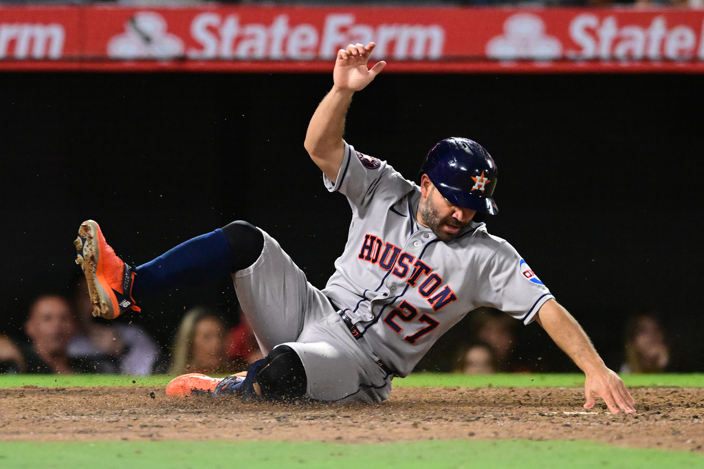 Houston Astros Jose Altuve (27) scores a run against the Los Angeles Angels during the seventh inning of a baseball game Wednesday, July 29, 2026, in Anaheim, Calif. (AP Photo/Wally Skalij)